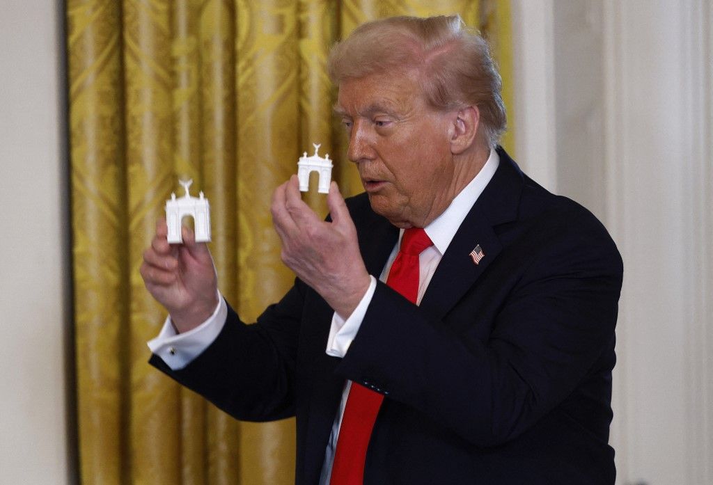 Trump muestra dos modelos de altura diferente del 'Arco del Triunfo' que quiere construir.