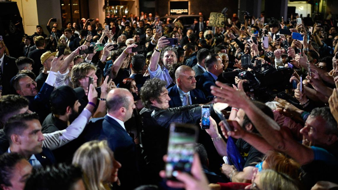 President Javier Milei greets supporters as he celebrates outside the ruling party's La Libertad Avanza headquarters after the results of the national midterm legislative election in Buenos Aires on October 26, 2025. 