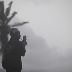 Un hombre usa su celular en el paseo marítimo de Kingston. El huracán Melissa amenazó a Jamaica con lluvias potencialmente mortales. Foto de Ricardo Makyn / AFP | Foto:AFP
