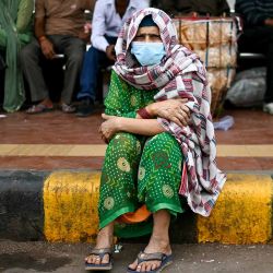Una mujer mayor con mascarilla se sienta junto a una carretera en medio de condiciones de smog en Nueva Delhi. Foto de Arun SANKAR / AFP | Foto:AFP