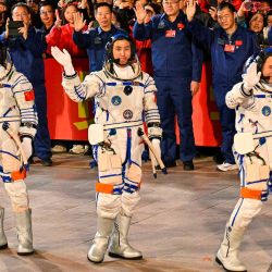 Astronautas de la misión espacial Shenzhou-21 de China, durante una ceremonia antes de abordar la nave en el Centro de Lanzamiento de Satélites de Jiuquan en el desierto de Gobi. Foto de Hector RETAMAL / AFP | Foto:AFP