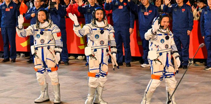 Astronautas de la misión espacial Shenzhou-21 de China, durante una ceremonia antes de abordar la nave en el Centro de Lanzamiento de Satélites de Jiuquan en el desierto de Gobi. Foto de Hector RETAMAL / AFP