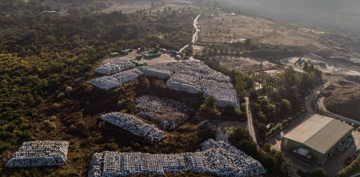 La foto aérea muestra cientos de fardos de desechos envueltos en plástico almacenados junto a una fábrica de reciclaje en la ciudad de la isla de Corfú. Foto de Angelos TZORTZINIS / AFP