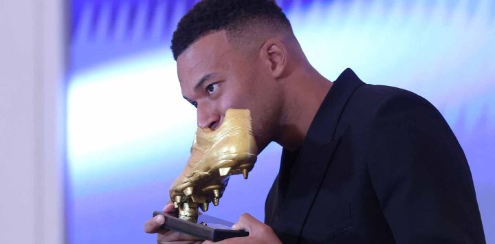 El delantero francés del Real Madrid, Kylian Mbappé, besa su trofeo tras recibir el premio Bota de Oro Europea. Foto de Oscar DEL POZO / AFP 