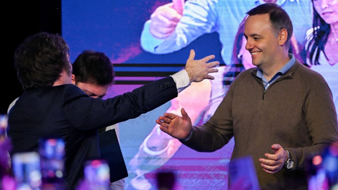 Argentina's President Javier Milei greets Presidential Spokesperson Manuel Adorni at the ruling party's La Libertad Avanza headquarters following the results of the national midterm legislative election in Buenos Aires on October 26, 2025.