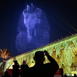 Drones iluminados que reproducen la máscara funeraria del antiguo rey egipcio Tutankamón iluminan el cielo durante la ceremonia de inauguración del Gran Museo Egipcio (GEM) en Guiza, en las afueras suroccidentales de El Cairo. | Foto:Khaled Desouki / AFP