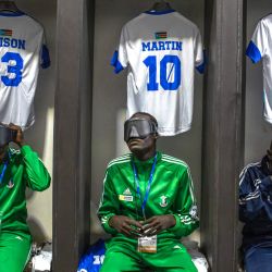 Jugadores de la selección de fútbol para ciegos de Sudán del Sur se visten con sus uniformes en el vestuario mientras se preparan para un partido en el Estadio Hamz, en el área conmemorativa de guerra de Nakivubo, en Kampala. | Foto:Stuart Tibaweswa / AFP