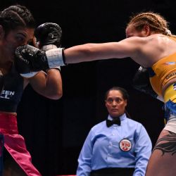 La argentina Gabriela Celeste Alaniz conecta un zurdazo a la colombiana Laura Wollenmann durante su combate por el título de peso mosca (112 libras) en la 38ª Convención Anual de la OMB, Noche de Campeones, en el centro de eventos multiformato Ágora de Bogotá. | Foto:Raúl Arboleda / AFP