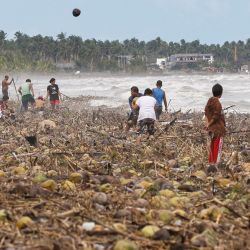 En la localidad de Mayorga, provincia de Leyte, la gente recogía cocos arrastrados a la costa por el tifón Kalmaegi. Al menos cinco personas murieron y cientos de miles fueron desplazadas debido a las intensas lluvias provocadas por el tifón Kalmaegi, que inundaron amplias zonas del centro de Filipinas ese mismo día. | Foto:FRANCIS CADAVIS / AFP