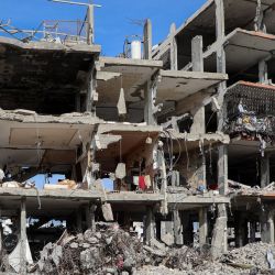 Imagen de palestinos de pie en un edificio destruido, en el campamento de refugiados de Jabalia, en el norte de Gaza. | Foto:Xinhua/Rizek Abdeljawad