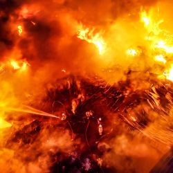 Vista aérea tomada con un dron de bomberos intentando apagar un incendio en una fábrica, en la gobernación de Jahra, Kuwait. | Foto:Xinhua/Asad