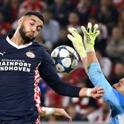 El centrocampista marroquí del PSV Eindhoven, Ismael Saibari, cabecea la pelota mientras el arquero griego del Olympiakos, Kostas Tzolakis, intenta bloquearlo durante el partido de la cuarta jornada de la primera ronda de la Liga de Campeones de la UEFA entre el Olympiakos (GRE) y el PSV Eindhoven (NED) en el estadio Karaiskakis de El Pireo. | Foto:ARIS MESSINIS / AFP