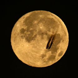 Un avión sobrevuela la luna llena de noviembre, también conocida como "Luna del Castor", sobre el distrito financiero de Fráncfort del Meno, en el oeste de Alemania. | Foto:KIRILL KUDRYAVTSEV / AFP