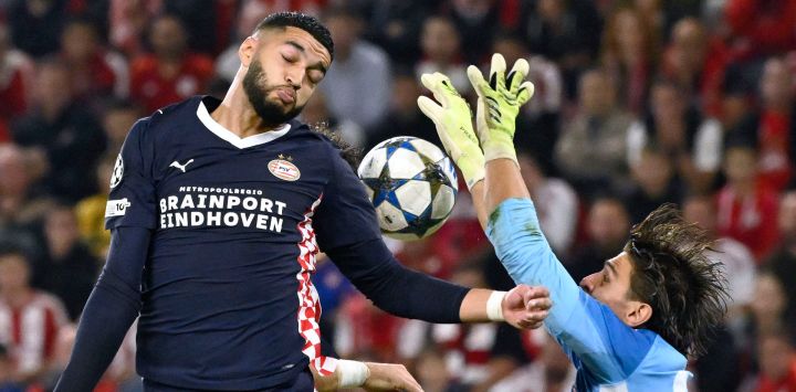 El centrocampista marroquí del PSV Eindhoven, Ismael Saibari, cabecea la pelota mientras el arquero griego del Olympiakos, Kostas Tzolakis, intenta bloquearlo durante el partido de la cuarta jornada de la primera ronda de la Liga de Campeones de la UEFA entre el Olympiakos (GRE) y el PSV Eindhoven (NED) en el estadio Karaiskakis de El Pireo.