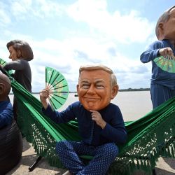 Activistas de Oxfam, con máscaras gigantes que representan (de izquierda a derecha) a la presidenta de la Comisión Europea, Ursula von der Leyen; al presidente de Sudáfrica, Cyril Ramaphosa; al presidente de Argentina, Javier Milei; al presidente de Estados Unidos, Donald Trump; y al primer ministro de Canadá, Marck Carney, posan durante su protesta "Cabezas Gigantes" en la ribera del río de la Universidad Federal de Pará (Orla da UFPA), Belém, Brasil, en el marco de la Cumbre del Clima COP30 de la ONU. | Foto:MAURO PIMENTEL / AFP