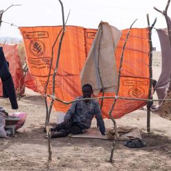 Un hombre sudanés desplazado que huyó de El-Fasher después de que la ciudad cayera en manos de las Fuerzas de Apoyo Rápido (FAR), se encuentra sentado en un refugio improvisado en el campamento de Um Yanqur, ubicado en el extremo suroeste de Tawila, en la región occidental de Darfur, en Sudán, devastada por la guerra. | Foto:AFP