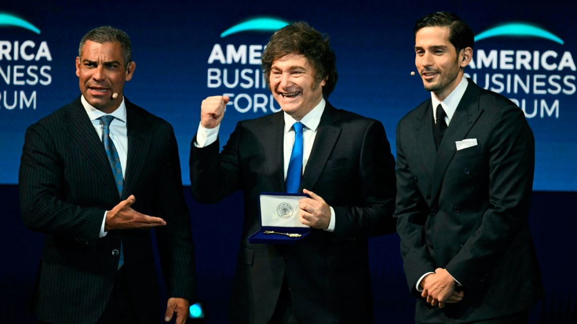 Argentina's President Javier Milei gestures after receiving a key to the city of Miami from Miami Mayor Francis Suarez (left) during the American Business Forum at the Kaseya Center in Miami on November 6, 2025. 