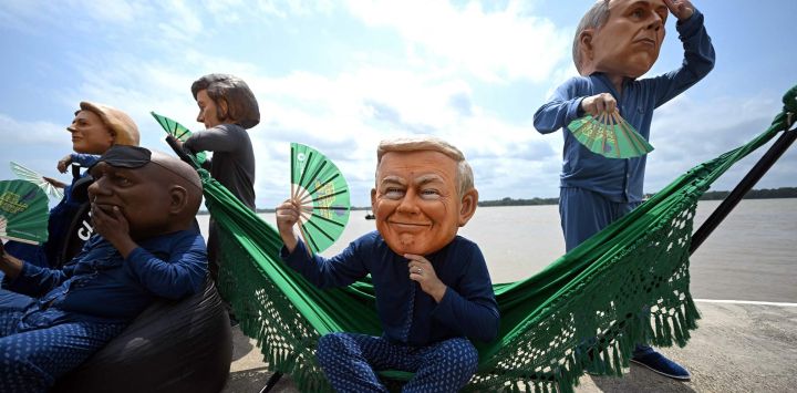 Activistas de Oxfam, con máscaras gigantes que representan (de izquierda a derecha) a la presidenta de la Comisión Europea, Ursula von der Leyen; al presidente de Sudáfrica, Cyril Ramaphosa; al presidente de Argentina, Javier Milei; al presidente de Estados Unidos, Donald Trump; y al primer ministro de Canadá, Marck Carney, posan durante su protesta "Cabezas Gigantes" en la ribera del río de la Universidad Federal de Pará (Orla da UFPA), Belém, Brasil, en el marco de la Cumbre del Clima COP30 de la ONU.