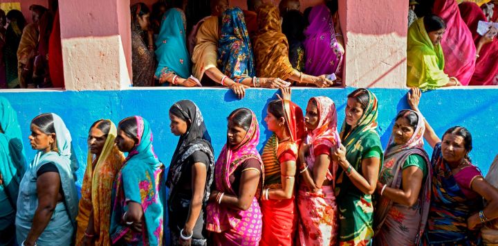 Mujeres votantes hacen fila para emitir su voto en un colegio electoral durante la primera fase de las elecciones a la asamblea legislativa en la circunscripción de Raghopur, distrito de Vaishali, estado indio de Bihar.