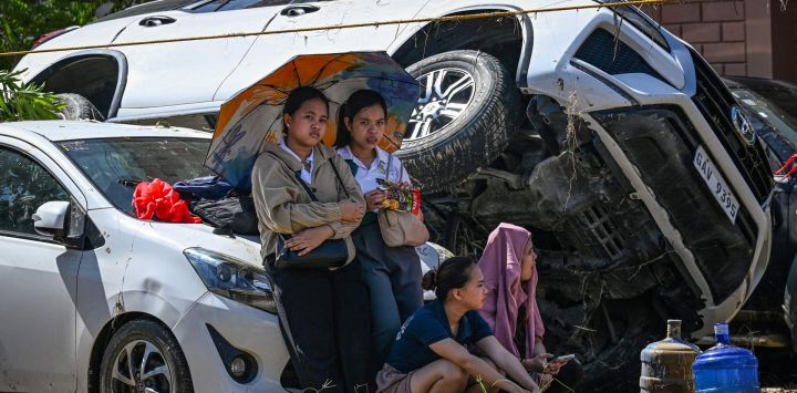 Personas descansan junto a sus autos, apilados unos sobre otros por las inundaciones provocadas por el tifón Kalmaegi, en Liloan, provincia de Cebú. El tifón Kalmaegi causó la muerte de al menos 140 personas y dejó a otras 127 desaparecidas tras provocar devastadoras inundaciones en el centro de Filipinas, según cifras oficiales.