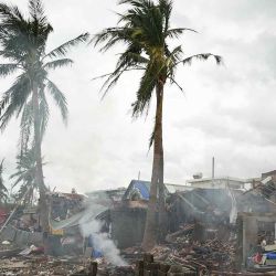 Residentes queman madera de sus casas destruidas cerca del malecón en Garchitorena, provincia de Camarines Sur, al sur de Manila. Foto de Charism SAYAT / AFP | Foto:AFP