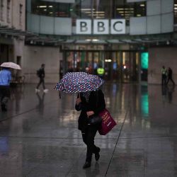 Personas se resguardan de la lluvia frente a la entrada de la BBC en Londres. Foto de HENRY NICHOLLS / AFP | Foto:AFP