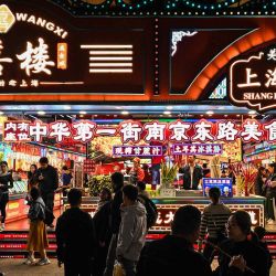 Personas caminan frente a tiendas de comida en una calle peatonal del distrito de Huangpu en Shanghái. Foto de Hector RETAMAL / AFP | Foto:AFP