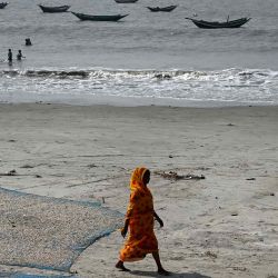 Una trabajadora pasa junto a pescados y camarones extendidos para secarse en la playa de un pueblo de pescadores en la isla de Mousuni, Bengala Occidental. Foto de DIBYANGSHU SARKAR / AFP | Foto:AFP