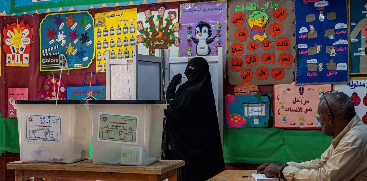 Una votante se prepara para depositar su voto en un colegio electoral de Guiza, ciudad gemela de El Cairo. Foto de Khaled DESOUKI / AFP