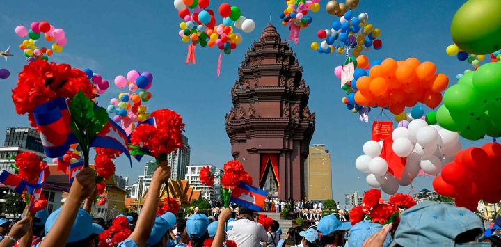 Estudiantes camboyanos sostienen flores mientras se sueltan globos en el Monumento a la Independencia. Camboya, en Phnom Penh.  Foto de TANG CHHIN Sothy / AFP