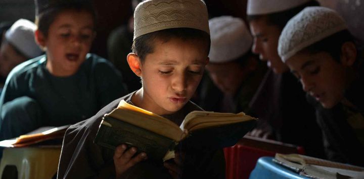 Niños afganos leen el sagrado Corán en una madrasa, o escuela islámica, en el distrito de Fayzabad, provincia de Badakhshan. Foto de Omer ABRAR / AFP