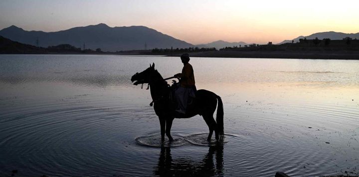 Un niño afgano monta a caballo en el lago Qargha, en las afueras de Kabul. Foto de Wakil KOHSAR / AFP
