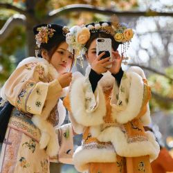 Dos mujeres vestidas con trajes tradicionales se toman una selfie mientras caminan por un sendero en Beijing. Foto de WANG Zhao / AFP | Foto:AFP