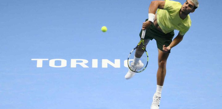 El español Carlos Alcaraz saca contra el estadounidense Taylor Fritz durante el torneo de tenis ATP Finals en Turín. Foto de Marco BERTORELLO / AFP