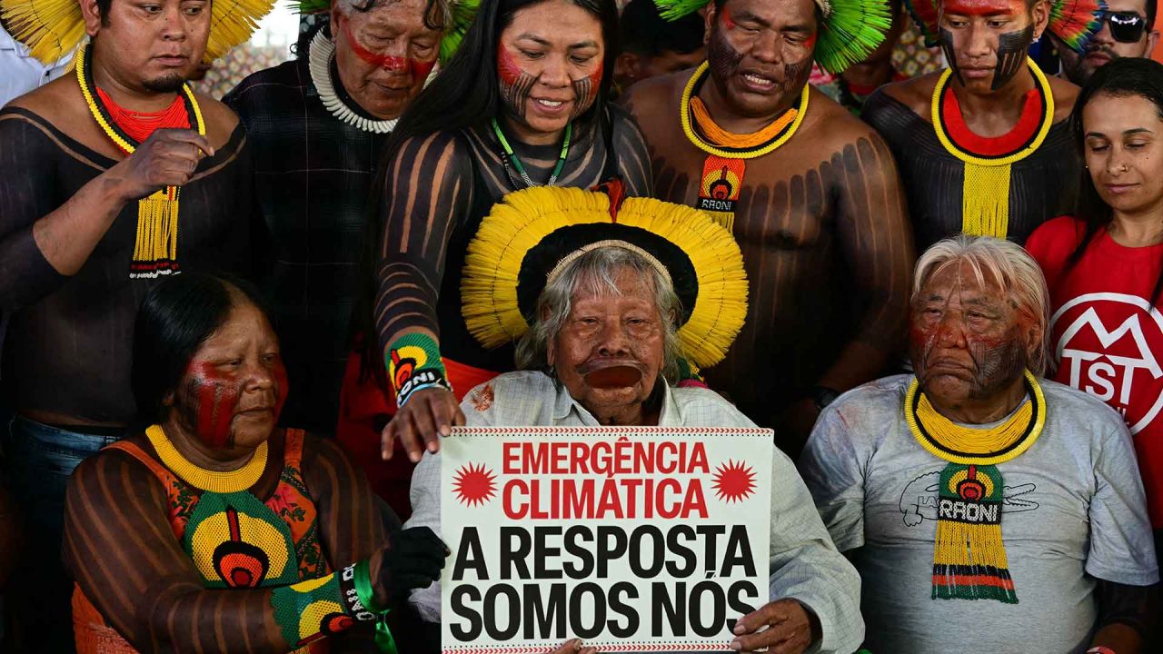 El líder indígena y ambientalista brasileño, el Jefe Raoni, sostiene un cartel que dice "Emergencia climática. La respuesta somos nosotros". Foto de Pablo PORCIUNCULA / AFP | Foto:AFP