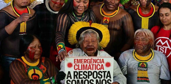 El líder indígena y ambientalista brasileño, el Jefe Raoni, sostiene un cartel que dice "Emergencia climática. La respuesta somos nosotros". Foto de Pablo PORCIUNCULA / AFP