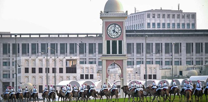 Guardias reales montados en camellos patrullan alrededor del Amiri Diwan en Doha. Foto de MAHMUD HAMS / AFP