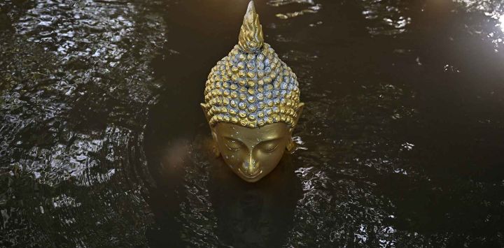 Aguas cubren una estatua de Buda en el templo budista Wat Taku en el distrito de Bang Ban, en la provincia central tailandesa de Ayutthaya. Foto de Lillian SUWANRUMPHA / AFP