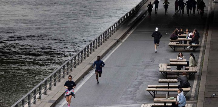 Corredores corren a lo largo de las orillas del río Sena en París. Foto de JOEL SAGET / AFP