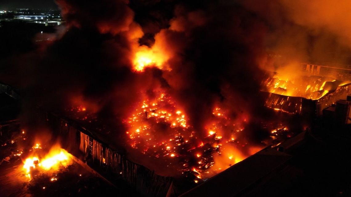This aerial view shows a fire after an explosion in an industrial area of Ezeiza in Buenos Aires Province on November 15, 2025. Powerful explosions rocked an industrial area and ignited a fire south of Buenos Aires on the night of November 14, 2025, officials said, with at least 22 people sent to the hospital. 