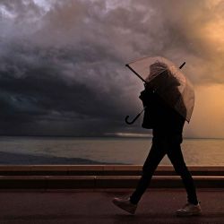 Un peatón camina con un paraguas junto al mar Mediterráneo durante las fuertes lluvias en la ciudad de Niza, en la Riviera francesa. Foto de Valery HACHE / AFP | Foto:AFP