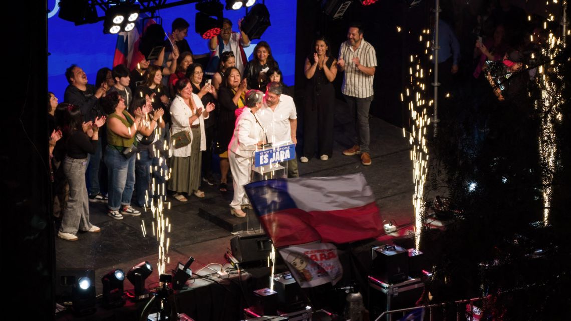 This aerial view shows Chile's presidential candidate Jeannette Jara, of the Unidad por Chile coalition, delivering a speech with her partner Claudio Rodríguez after the first exit poll results of the general election in Santiago on November 16, 2025.