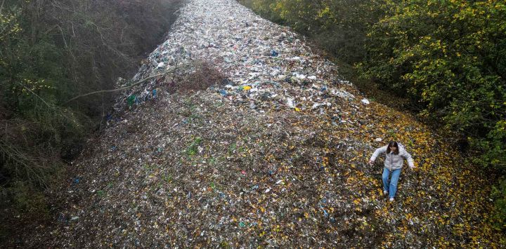 Activistas medioambientales grabando contenido sobre un gran montón de residuos vertidos ilegalmente, acumulados en un campo entre el río Cherwell y la A34 en Londres. Foto de Justin TALLIS / AFP