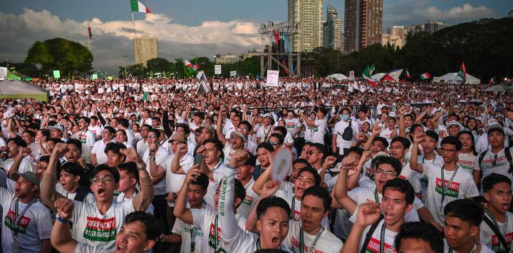Miembros de la secta religiosa Iglesia ni Cristo levantan puños cerrados mientras gritan consignas durante una protesta anticorrupción en un parque de Manila. Foto de Ted ALJIBE / AFP