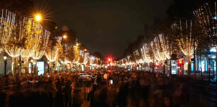 La gente camina por la avenida de los Campos Elíseos tras la inauguración de las iluminaciones navideñas en París. Foto de Dimitar DILKOFF / AFP