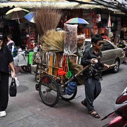 Un vendedor guía un carrito lleno de escobas y artículos de limpieza del hogar por el área de Chinatown en Bangkok. Foto de Lillian SUWANRUMPHA / AFP | Foto:AFP