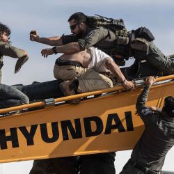 Fuerzas de seguridad israelíes se enfrentan con jóvenes colonos en un vehículo de tierra mientras evacuaban y demolían un asentamiento ilegal construido cerca del asentamiento judío de Metzad. Foto de Menahem KAHANA / AFP | Foto:AFP