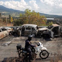 Inspeccionan el área donde cuatro vehículos fueron incendiados por presuntos miembros del crimen organizado en una carretera cerca de Quiroga, estado de Michoacán, México. Foto de Enrique CASTRO / AFP | Foto:AFP