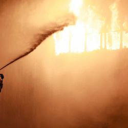 Un bombero utiliza una manguera de agua mientras trabaja para extinguir un incendio que envolvió varios pisos del rascacielos Vjesnik en Zagreb. Foto por AFP | Foto:AFP