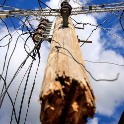 Un poste de electricidad roto por el huracán Melissa cuelga suspendido de los cables en El Cobre, Santiago de Cuba. Foto de AFP | Foto:AFP